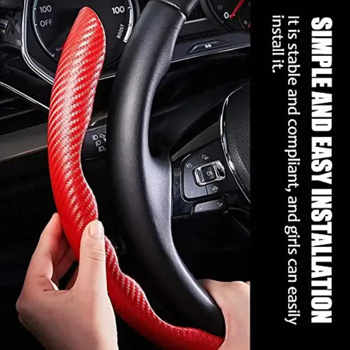 Red steering wheel cover with carbon fiber texture held by a hand inside a car.