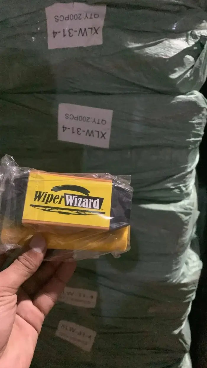 Packaged 'Wiper Wizard' product held in front of stacked green panels.