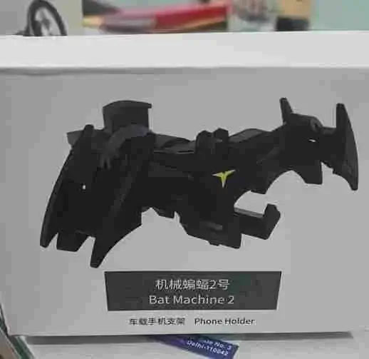 Black phone holder shaped like a bat on a white box with text