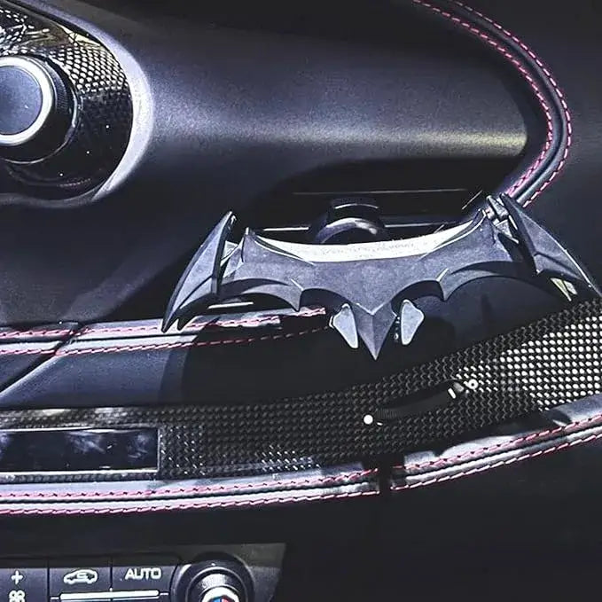 Car air freshener shaped like a bat with a dark interior background