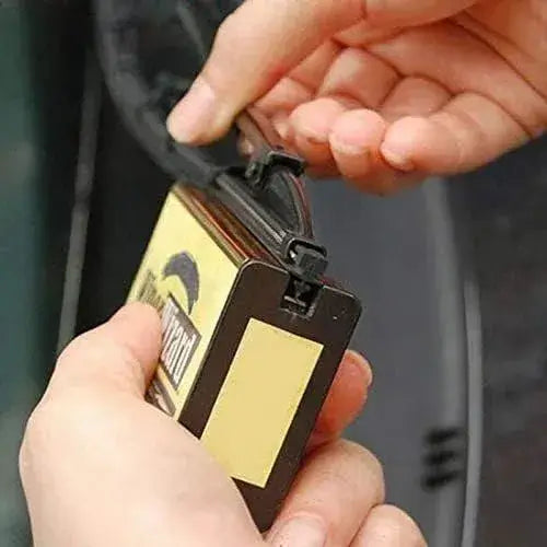 Person holding a luggage tag with a visible brand logo against a blurred background