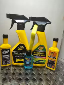 Collection of car care products including sprays and bottles on a metallic surface.