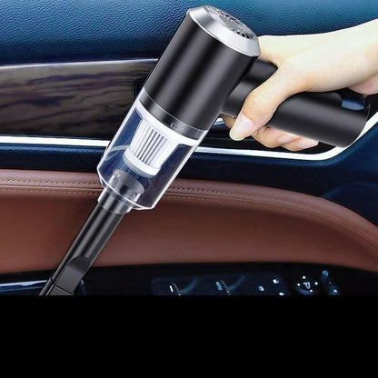 Hand holding a black car vacuum cleaner inside a vehicle.