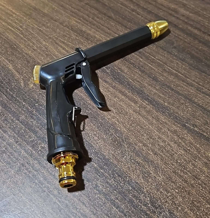 Black and gold garden hose nozzle on a wooden surface