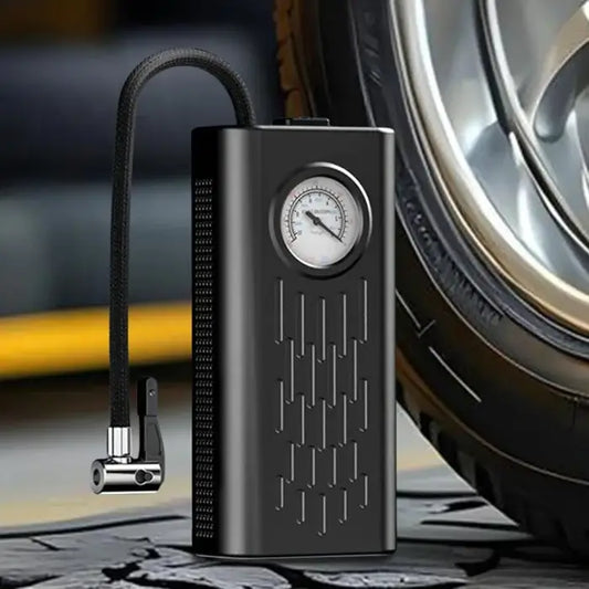 Black portable air compressor with pressure gauge next to a tire