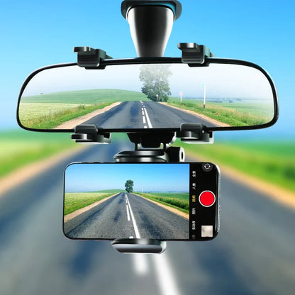 Premium 360° mobile phone holder mounted on a rearview mirror, capturing a scenic road view.